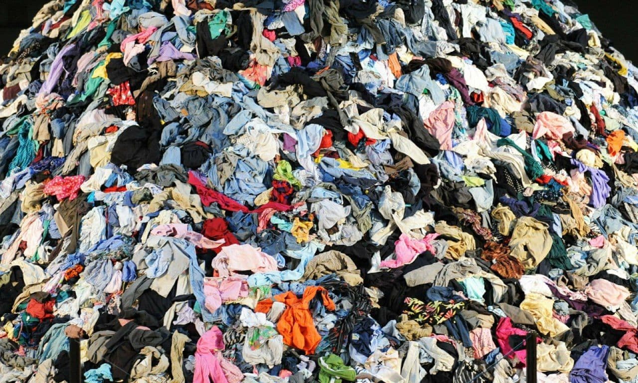 A landfill overflowing with piles of discarded clothes